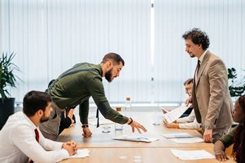 Men standing over table looking at paper - Employment Law